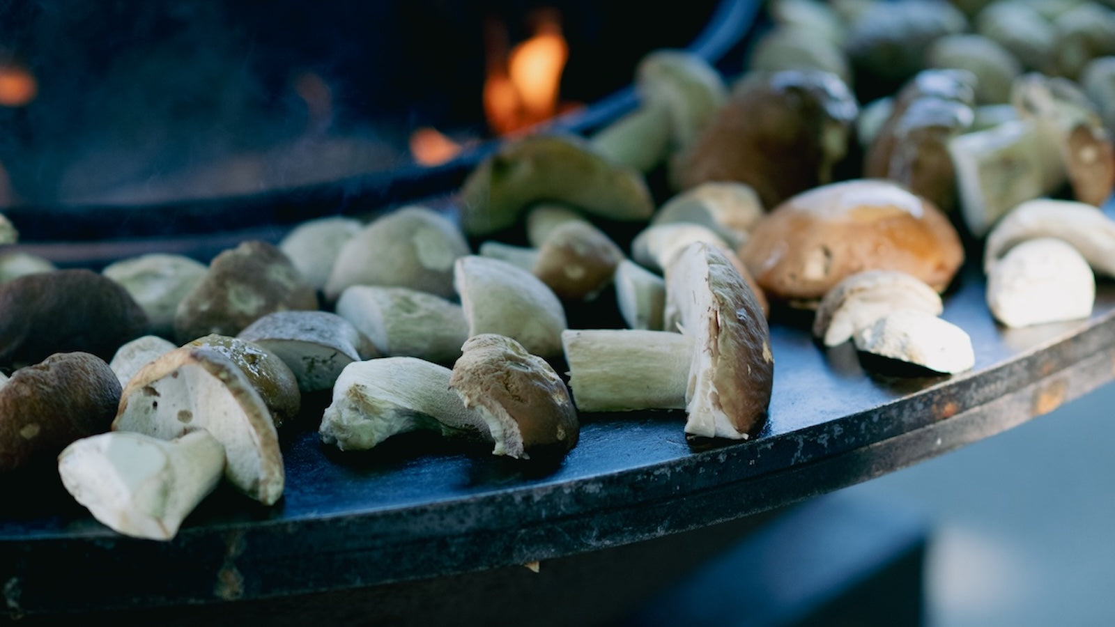 Crostini topped with sautéed porcini mushrooms, tomato and onion on the OFYR grill – a golden autumn appetiser bursting with umami flavour.
