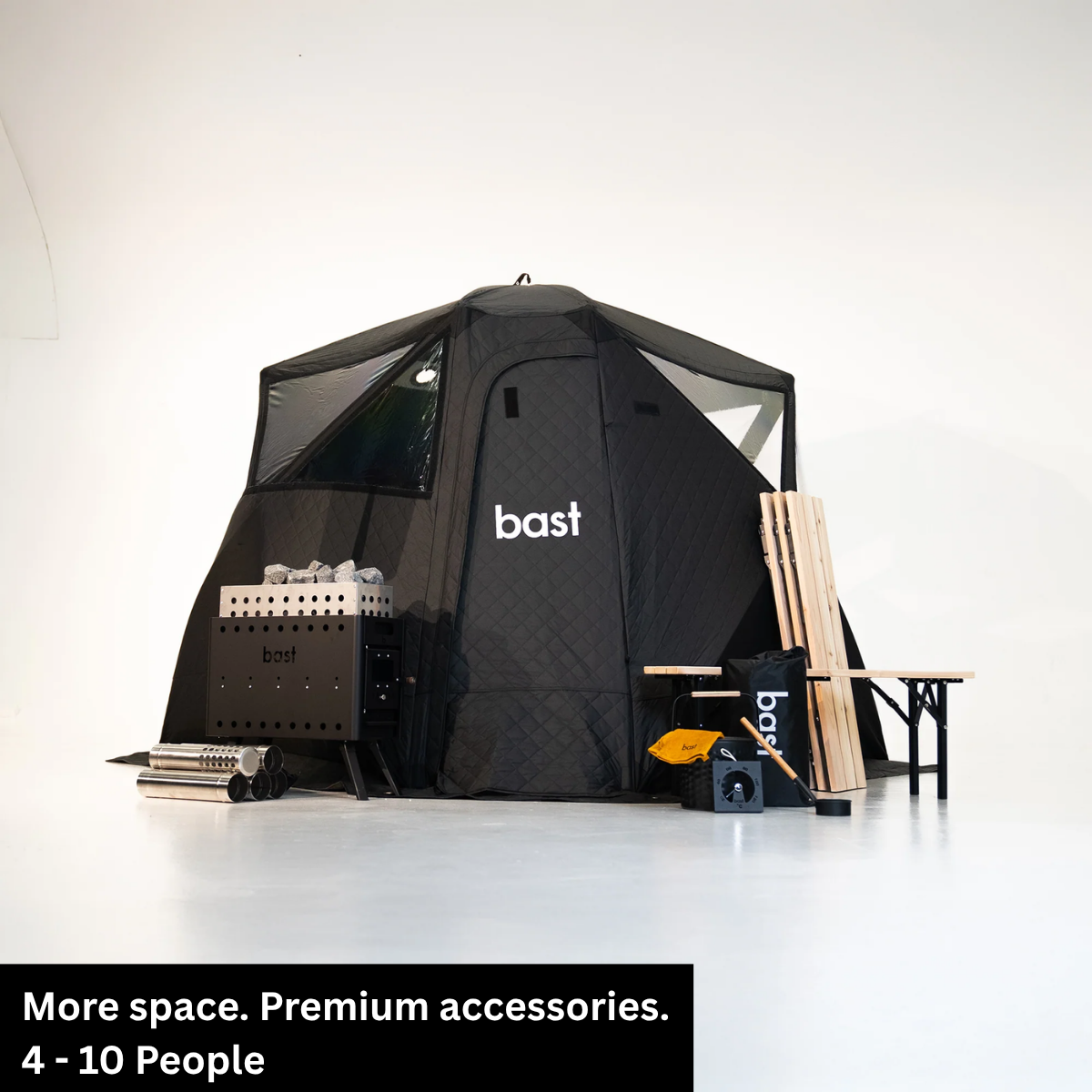 A black compact outdoor sauna tent  for 4-10 people, shown in a studio setup with all accessories included in the  BAST Björk Premium sauna tent kit.