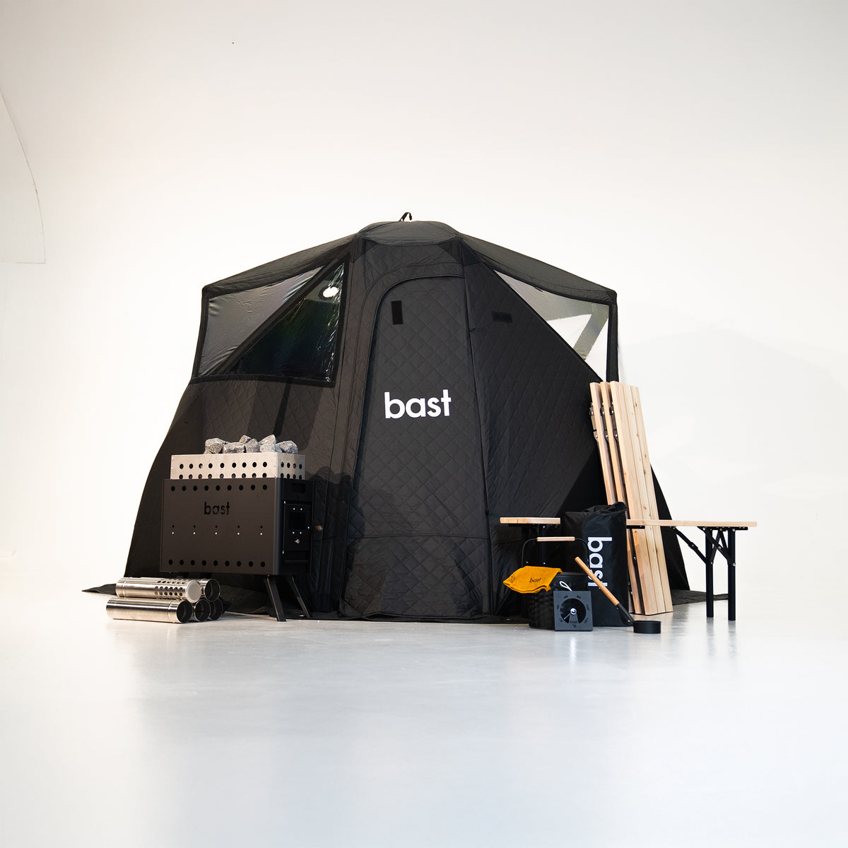 Black pop-up sauna tent kit for 4 - 10 people showing tent, stove, and accessories included in the premium kit.