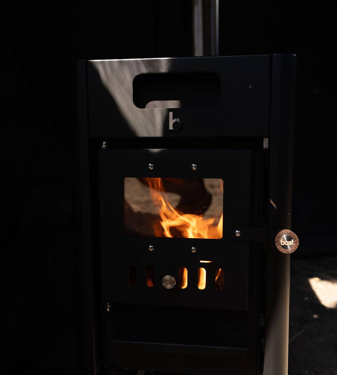 Wood-burning stove with visible flames against a dark background